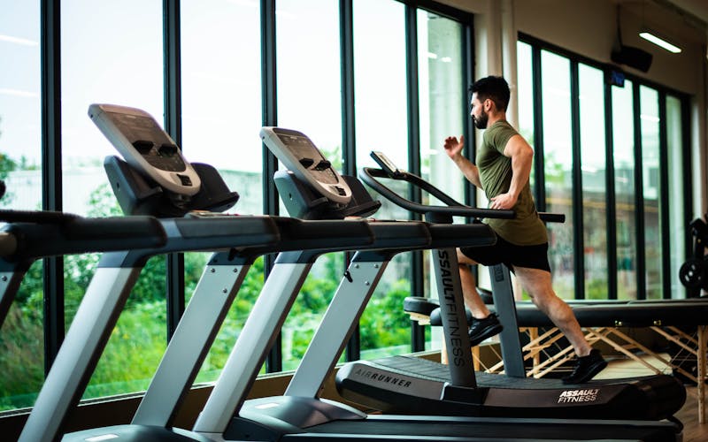 Man running on a treadmill in a modern gym